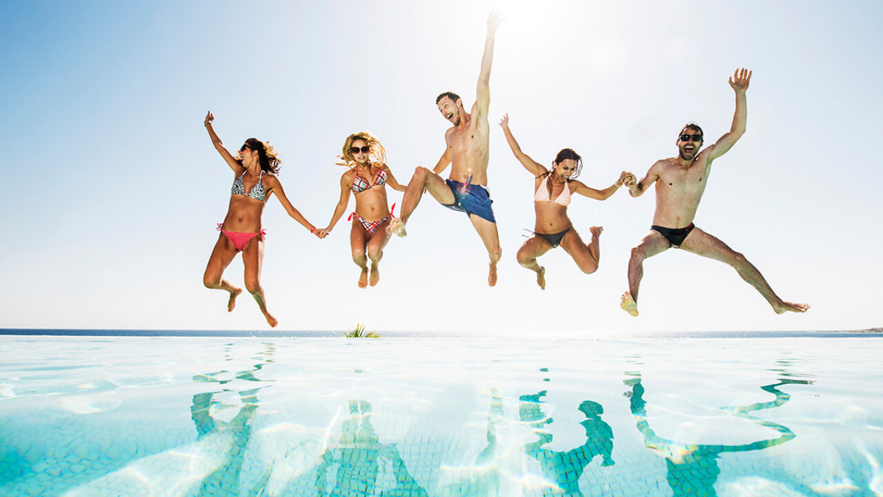 A person jumping into a swimming pool on a sunny day